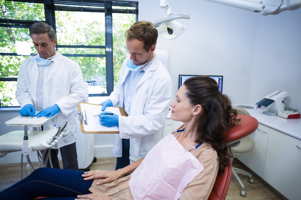 Dentist consulting with a female patient during a checkup in a modern dental office