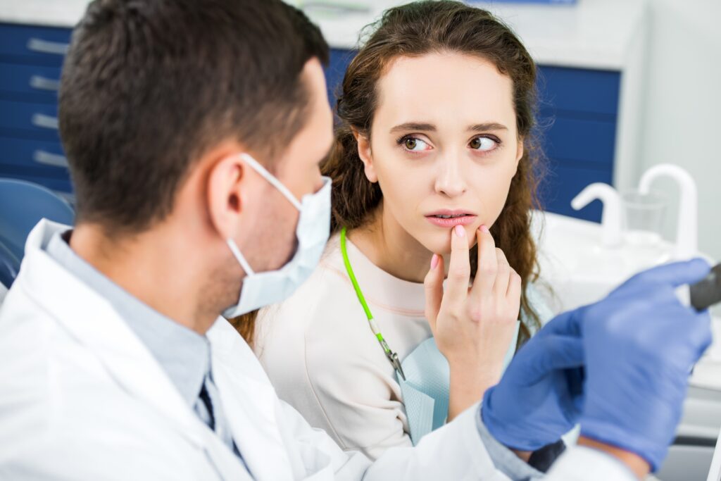 Dentist explaining gum disease symptoms to a female patient in a modern dental office in North Charleston